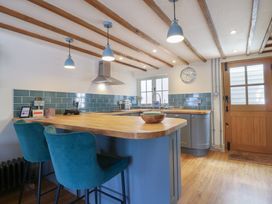 A kitchen with a sink and bar stools at The Annex Cavendish Near Sudbury