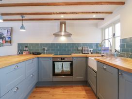 A kitchen with cabinets, cooker, and sink at The Annex Cavendish Near Sudbury