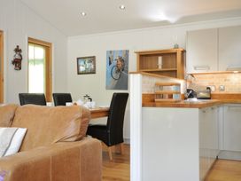 A kitchen with a dining table and seating at 11 Water's Edge near Pelynt