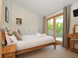 A bedroom with a bed and wardrobe at 11 Water's Edge near Pelynt