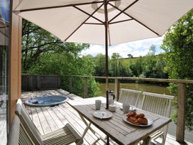 An outdoor terrace with a table and chairs at 11 Water's Edge near Pelynt