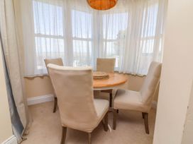 A dining room with a round table and four chairs at Sea Vista Westward Ho!