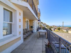 A balcony with outdoor seating and a table at Sea Vista in Westward Ho!