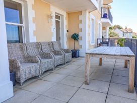 An outdoor seating area with a table and chairs at Sea Vista in Westward Ho!