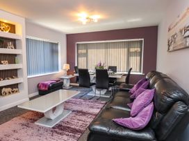 A living room with a sofa and dining table at Ger y Mynydd, 2 Cae Ty Coch in Brynteg