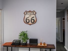 A hallway with a Route 66 sign and a desk with a plant at Ger y Mynydd, 2 Cae Ty Coch in Brynteg