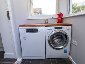 A laundry room with a dishwasher and washing machine at Ger y Mynydd, 2 Cae Ty Coch in Brynteg