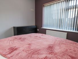 A bedroom with a bed, drawer unit, and window at Ger y Mynydd, 2 Cae Ty Coch, Brynteg