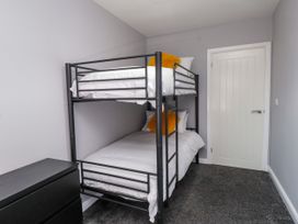 A bedroom with a bunk bed and dresser at Ger y Mynydd, 2 Cae Ty Coch in Brynteg