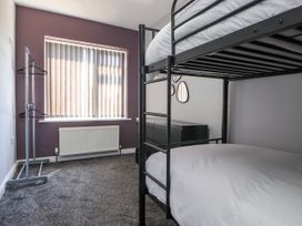 A bedroom with a bunk bed and a dresser at Ger y Mynydd, 2 Cae Ty Coch, Brynteg