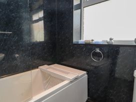 A bathroom with a bathtub and toilet at Ger y Mynydd, 2 Cae Ty Coch, Brynteg