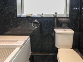 A bathroom with a bath tub and toilet at Ger y Mynydd, 2 Cae  Ty Coch in Brynteg