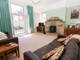 A living room with a fireplace and a television at Flat 3, 4 Park Road, Swanage