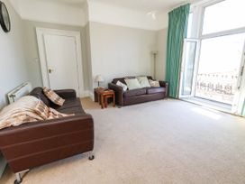 A living room with sofas and a door at Flat 3, 4 Park Road Swanage