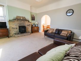 A living room with a fireplace and seating area at Flat 3, 4 Park Road in Swanage