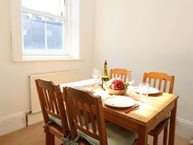 A dining room with a table set and a window at Flat 3, 4 Park Road in Swanage