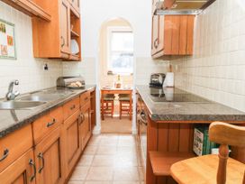 A kitchen with cabinets and a table at Flat 3, 4 Park Road in Swanage