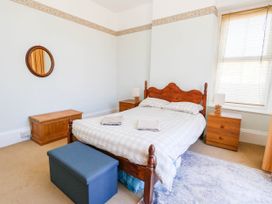 A bedroom with a bed and nightstand at Flat 3, 4 Park Road in Swanage