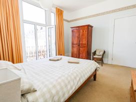 A bedroom with a bed and wardrobe at Flat 3, 4 Park Road in Swanage