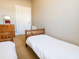 A bedroom with two single beds and a dresser at Flat 3, 4 Park Road in Swanage