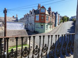 View from a balcony overlooking a street and buildings at Flat 3, 4 Park Road, Swanage