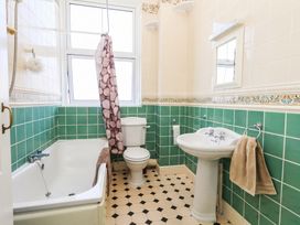 A bathroom with a bathtub, toilet, and sink at Flat 3, 4 Park Road in Swanage