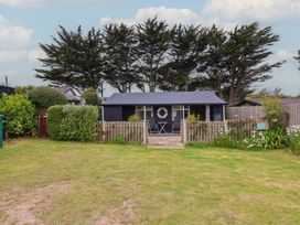 A garden with a building and chairs at Dingle Dell in Braunton