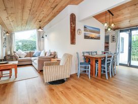 A living room with a sofa and dining area at Dingle Dell in Braunton