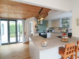 A kitchen with a counter and bar stools at Dingle Dell in Braunton
