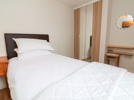A bedroom with a bed and wardrobe at Dingle Dell in Braunton