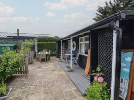 A garden area with a table and chairs near a house at Dingle Dell in Braunton