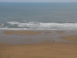 A beach with two people walking along the shore at Memory Maker in Bridlington