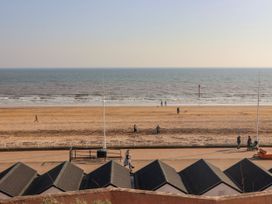 A beach scene with huts and people on the sand at Memory Maker in Bridlington