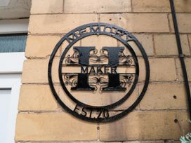 A decorative sign attached to a brick wall at Memory Maker in Bridlington