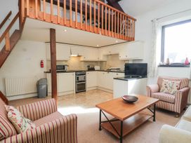 A living room with a kitchen area and seating at Rooftops in Lindale