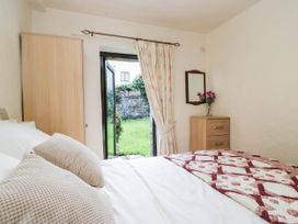 A bedroom with a bed and view to the garden at Rooftops in Lindale