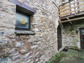 An exterior view showing a stone wall with a window and door at Rooftops in Lindale