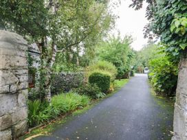 A pathway lined with trees and greenery at Rooftops in Lindale