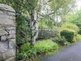 A garden with a stone wall and a path at Rooftops in Lindale