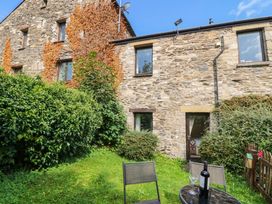 An outdoor area with a stone building and chairs at Rooftops in Lindale