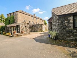 A stone building with a pathway and flower pots at Rooftops in Lindale