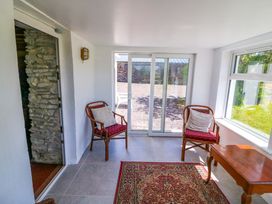 A conservatory with two chairs and a table at Tach Ferme
