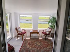 A conservatory with chairs and a table at Tach Ferme
