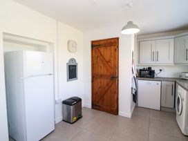 A kitchen with a refrigerator and wooden door at Tach Ferme
