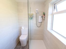 A bathroom with a shower, toilet and window at Tach Ferme
