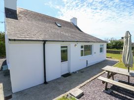 A house with a door and windows and a picnic table at Tach Ferme in 