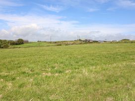 A field with green grass and buildings in the distance at Tach Ferme