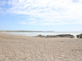 A beach with sand, water, and rocks at Tach Ferme in 
