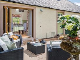 An outdoor seating area with a table and plant pot at Country Cottage Sleeps 3 with Garden and Parking