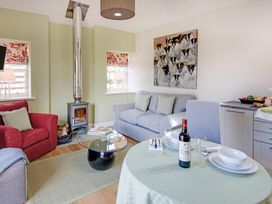 A living room with a sofa and dining table at Country Cottage Sleeps 3 with Garden and Parking